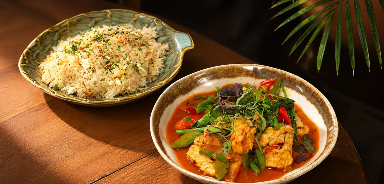 Chicken curry with green beans and Thai basil beside a dish of fried rice with spring onion at Nara Thai