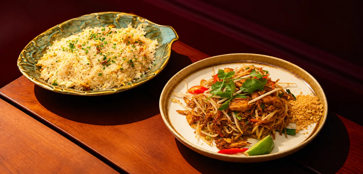 Pad thai with bean sprouts, crushed peanuts and lime beside a leaf-shaped dish of fried rice at Nara Thai